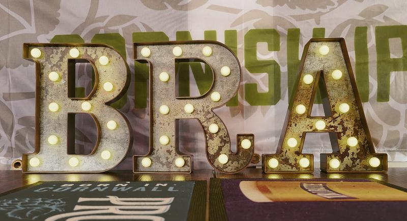 3 illuminated letters with visible bulbs inside. They spell out B R A.