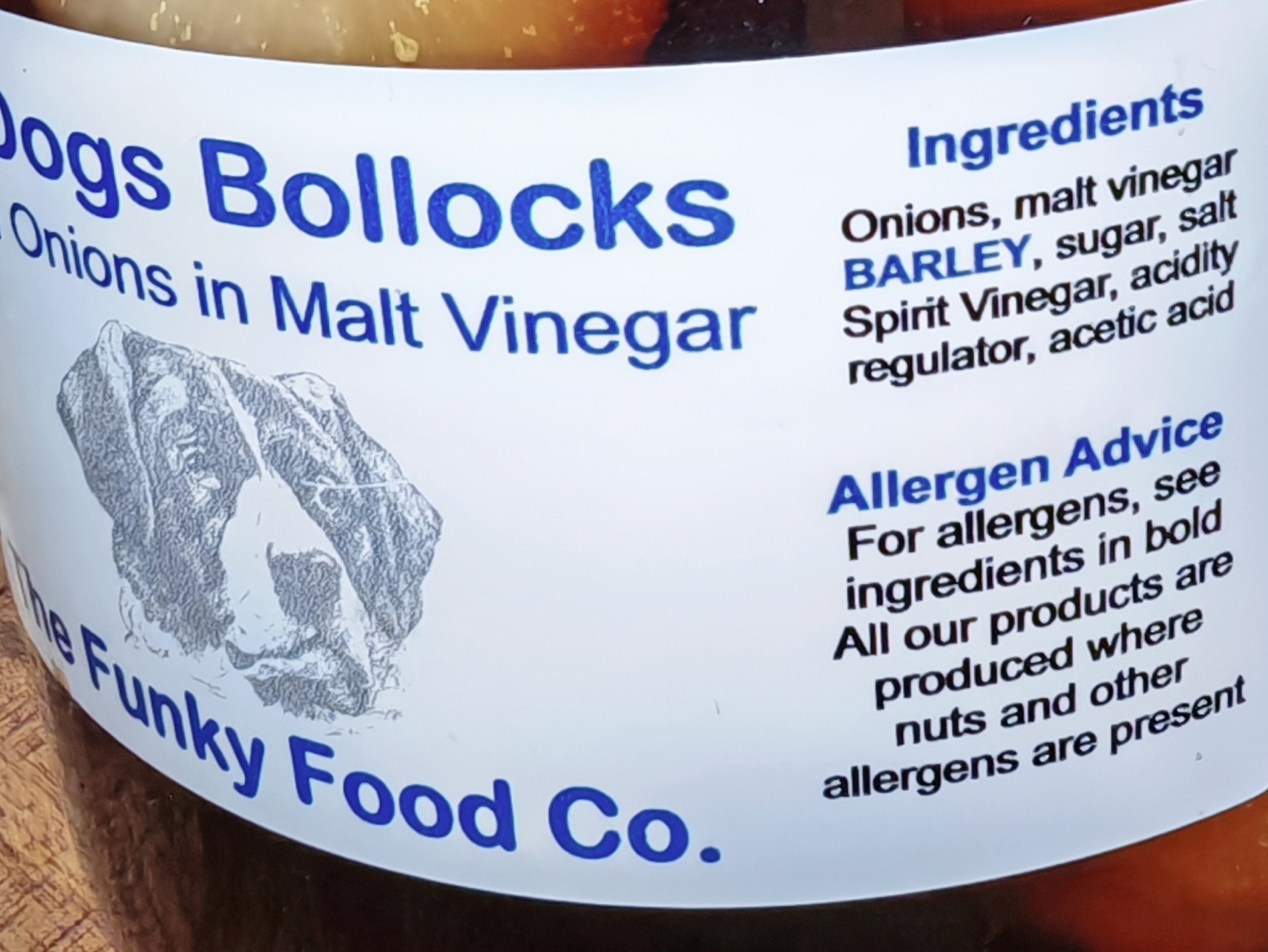 Photo: Close-up of the jar label showing ingredients list. The text reads "Onions, malt vinegar BARLEY, sugar, salt Spirit Vinegar, acidity regulator, acetic acid" with allergen advice noting that BARLEY is in bold. Part of The Funky Food Co. logo and the dog illustration are visible at the bottom of the label.