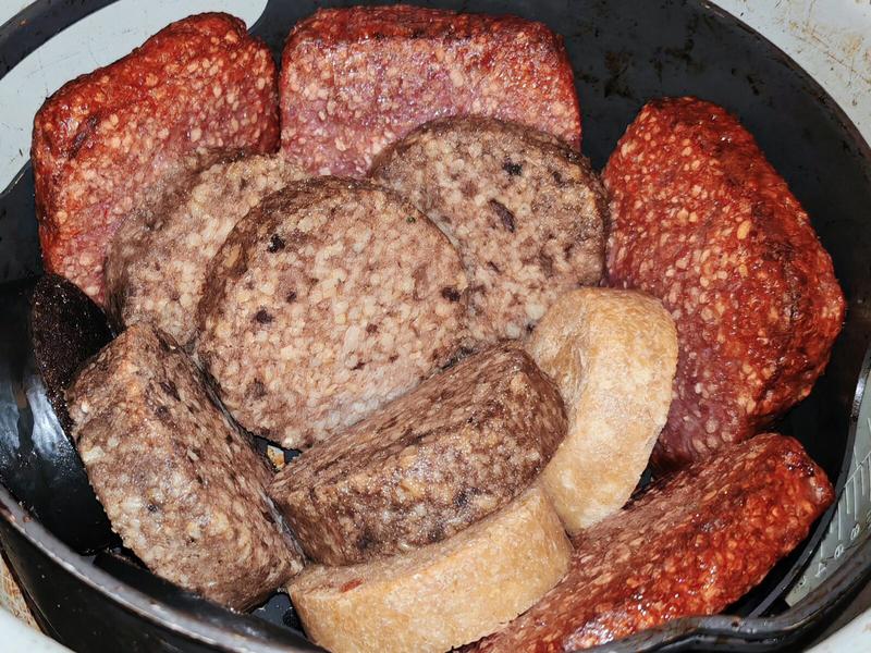 Photo: White pudding, black pudding, Lorne sausage and sliced haggis arranged in the basket of an air-fryer. The band forming ready for their performance.